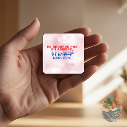 Tenant un aimant de réfrigérateur avec une citation inspirante.