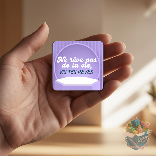 Tenant un aimant de réfrigérateur avec une citation inspirante.
