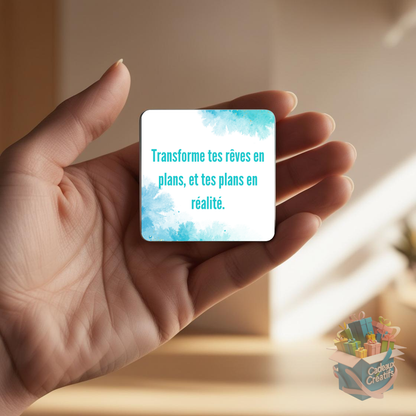 Tenant un aimant de réfrigérateur avec une citation inspirante.